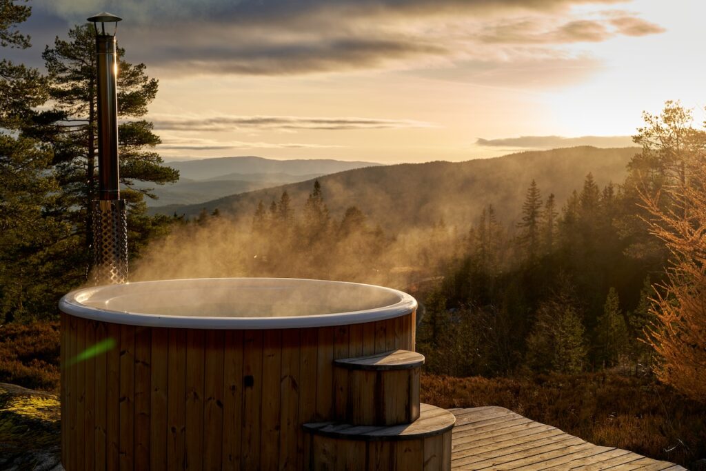 a scenic mountain view with a circular wooden hot tub
